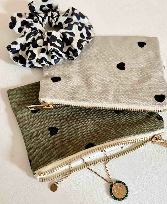 Mini pochette Marie Rose in April couleur sable avec imprimé petits cœurs noirs et bijoux.