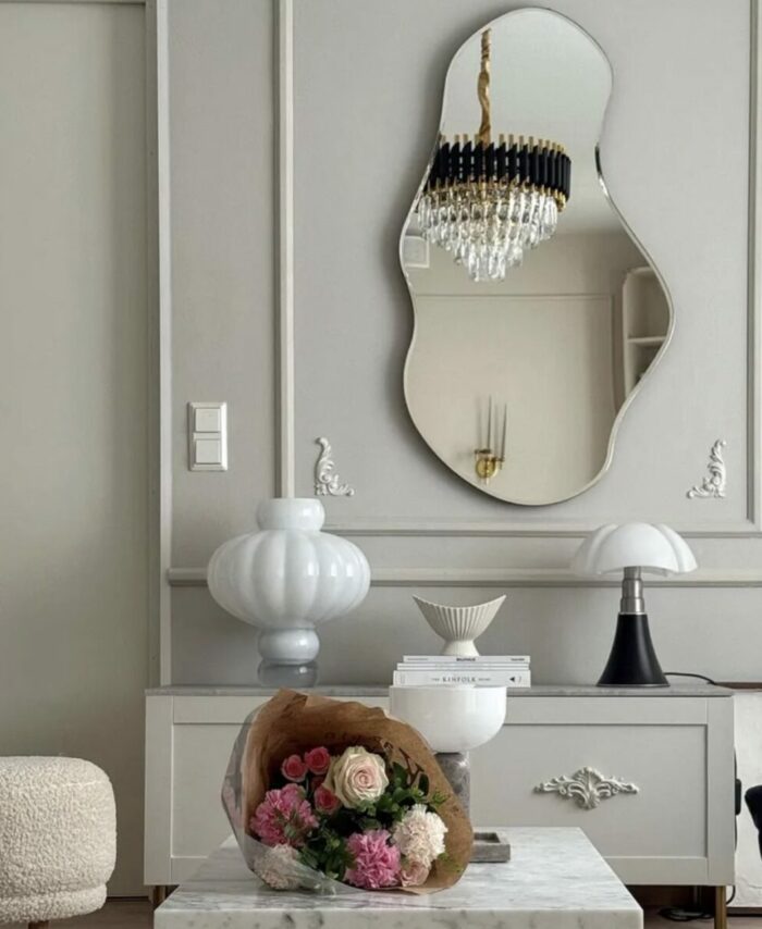 Grand miroir organique Pond Ferm Living avec cadre fin en métal dark chrome.