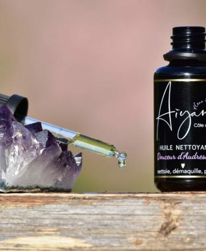 Huile nettoyante naturelle Douceur d'Audresselles Aiyana, pipette en verre déposant une goutte d'huile sur un cristal d'améthyste violette