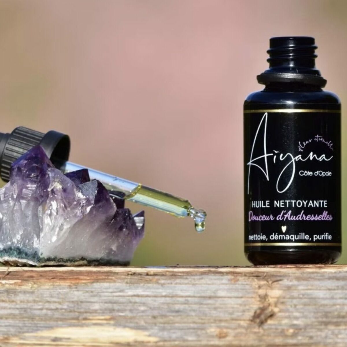 Huile nettoyante naturelle Douceur d'Audresselles Aiyana, pipette en verre déposant une goutte d'huile sur un cristal d'améthyste violette