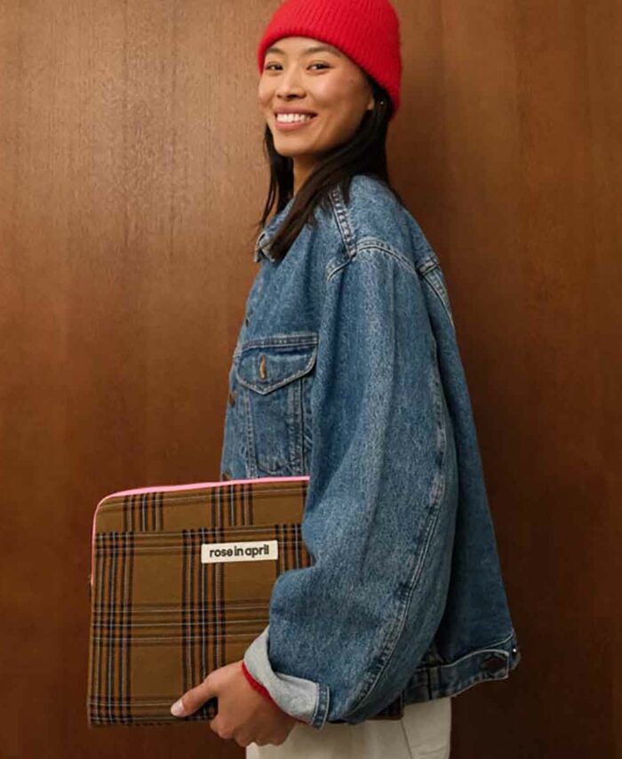 Jeune femme avec veste en jean tenant la housse d'ordinateur Octave marron.