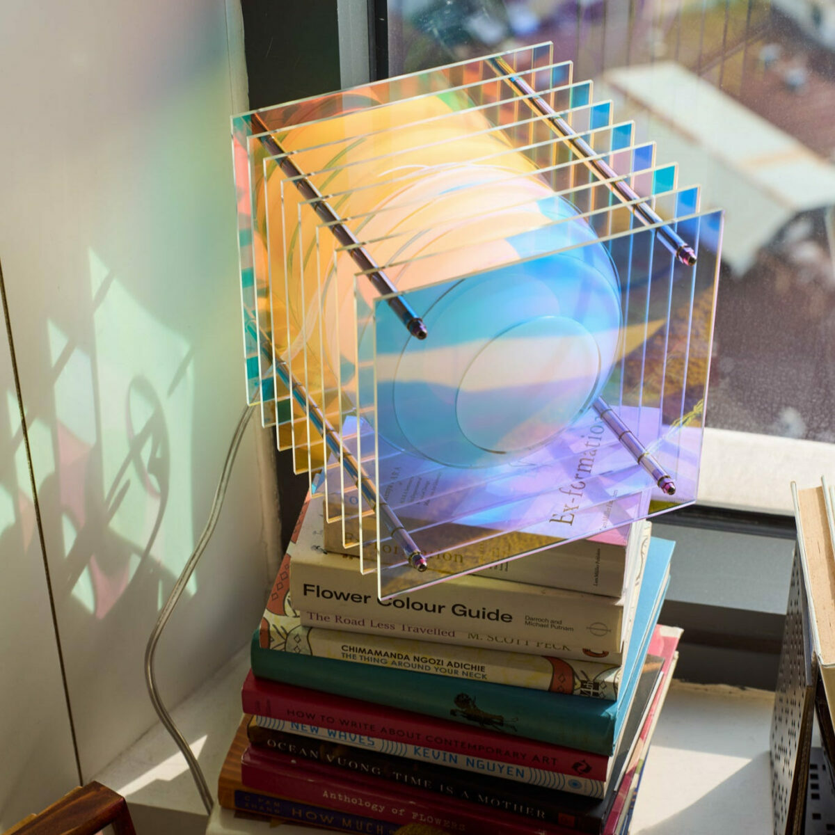 Vue d'angle de la lampe carrée Lớp montrant la superposition des couches d'acrylique et le socle en métal.