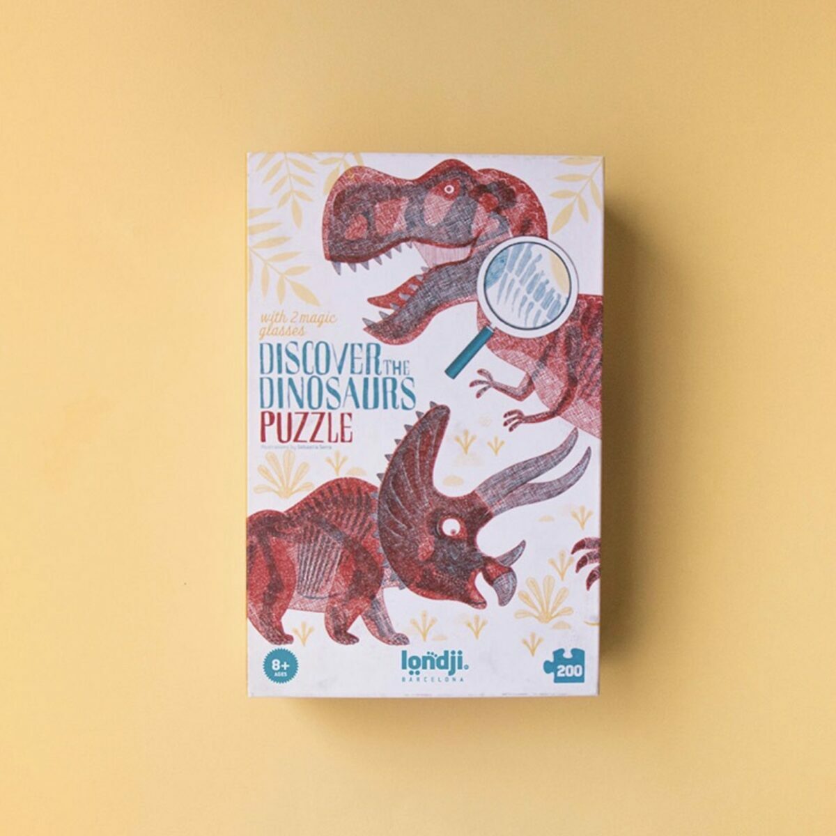 Boîte du puzzle Londji Discover the Dinosaurs montrant un T-Rex rouge et un squelette bleu.
