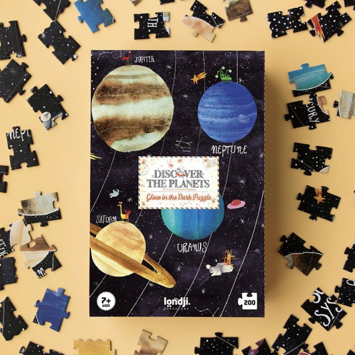 Boîte rectangulaire du puzzle Discover the Planets de Londji montrant une illustration du système solaire et la mention "Glow in the dark".