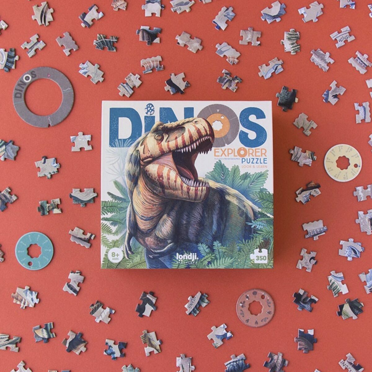 Boîte rectangulaire du puzzle Londji Dinos Explorer illustrant un T-Rex et les disques de données.