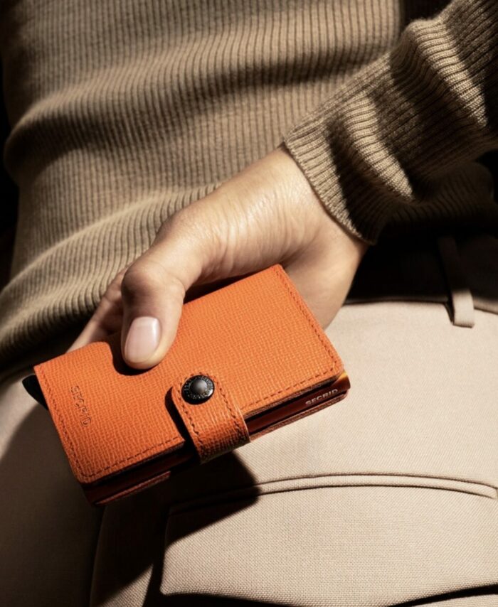 Secrid Miniwallet Crisple coloris Orange Citrouille, vue fermée de face dans une main