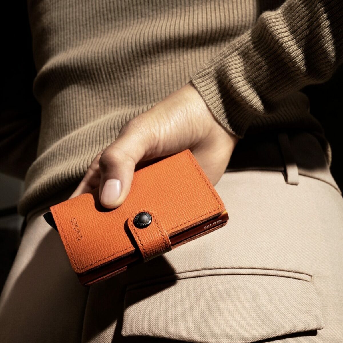 Secrid Miniwallet Crisple coloris Orange Citrouille, vue fermée de face dans une main